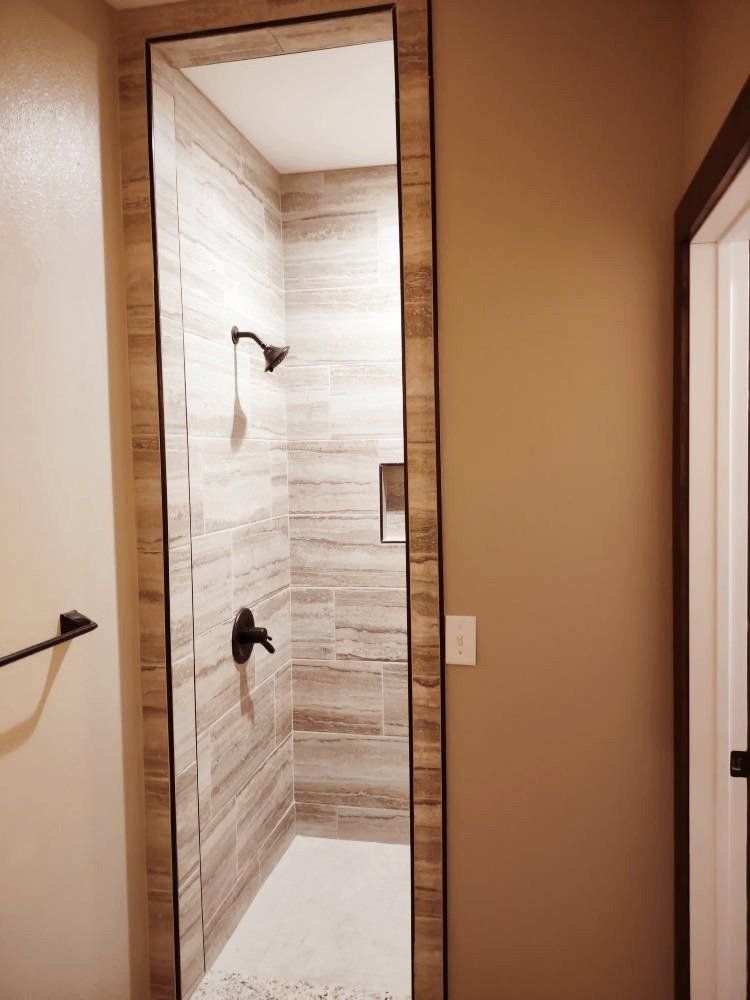 A bathroom with a walk in shower and a towel rack.