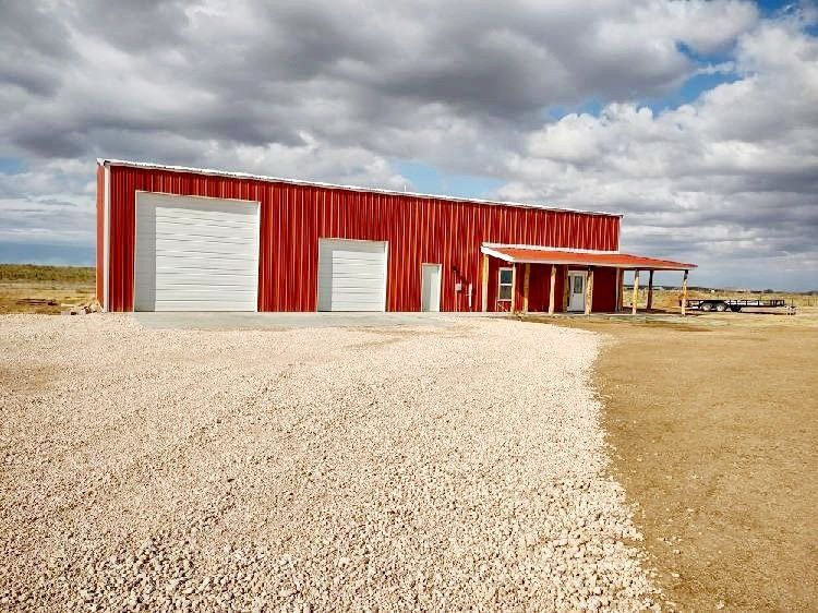 A large red building with white garage doors and a porch