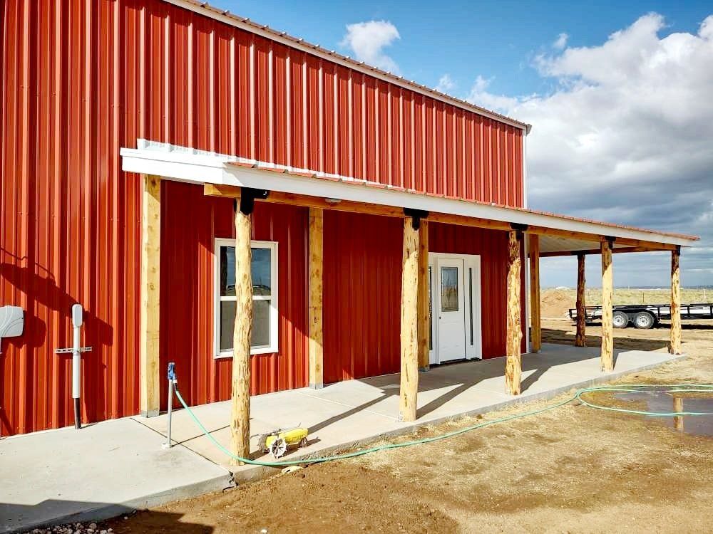 A red barn with a porch and a white door