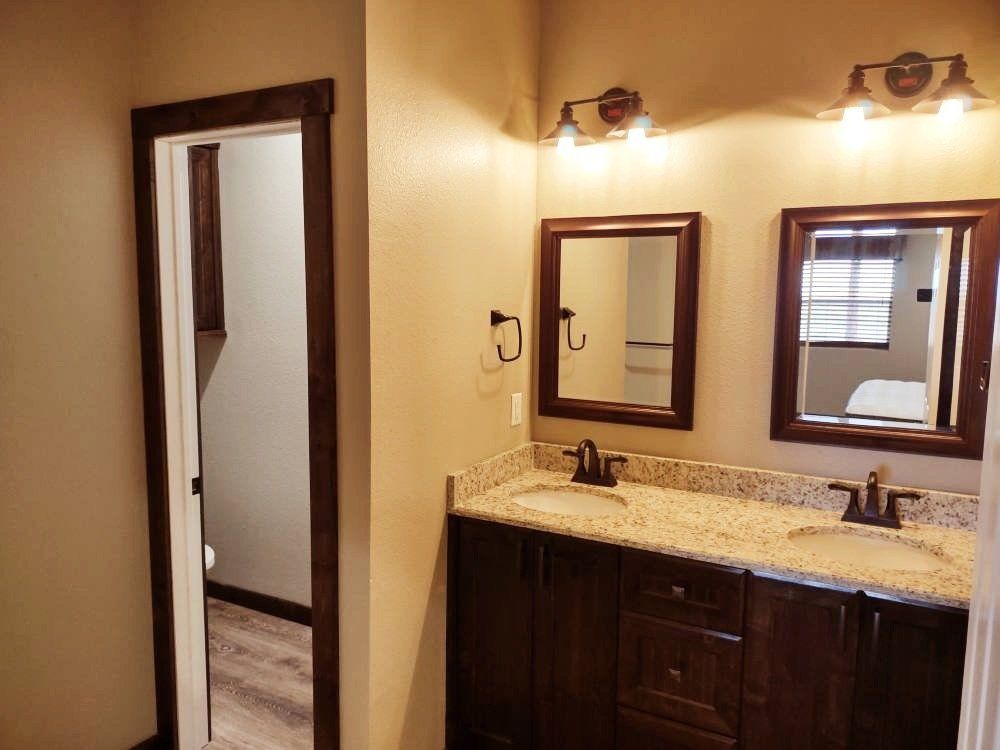 A bathroom with two sinks and two mirrors.