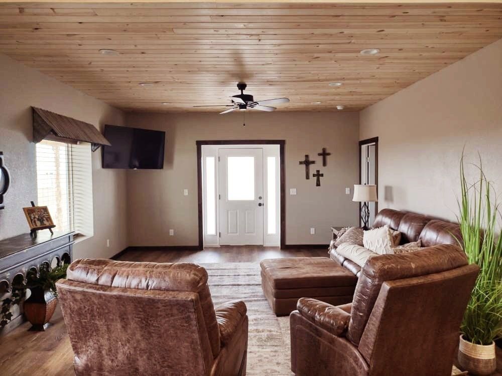 A living room with a couch , chairs , and a television.