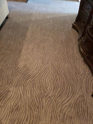 A bedroom with a zebra print carpet and a dresser.