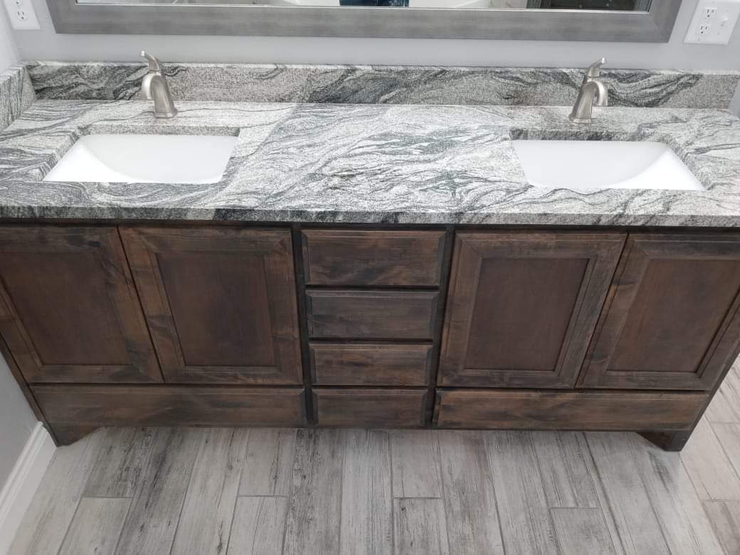 A bathroom vanity with two sinks and a mirror.