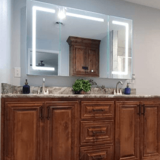 A bathroom with two sinks , a mirror and wooden cabinets.