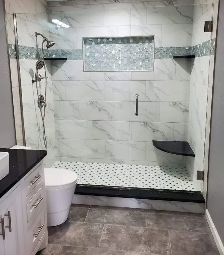 A bathroom with a walk in shower , toilet and sink.