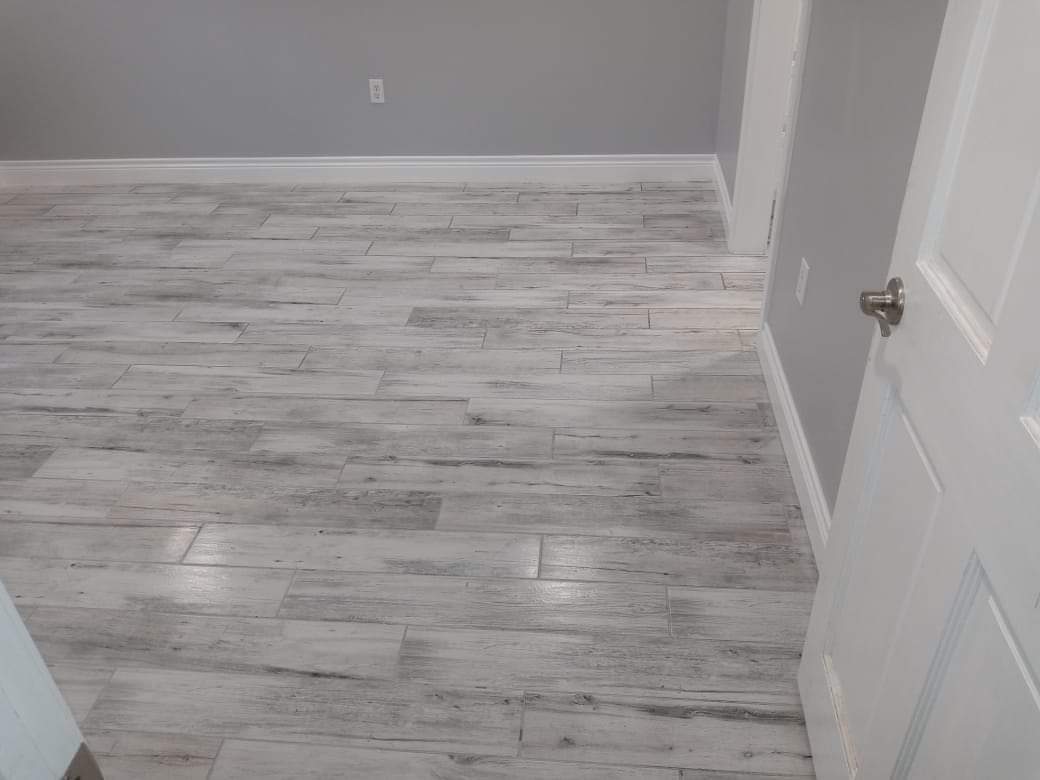 A room with a wooden floor and a white door.