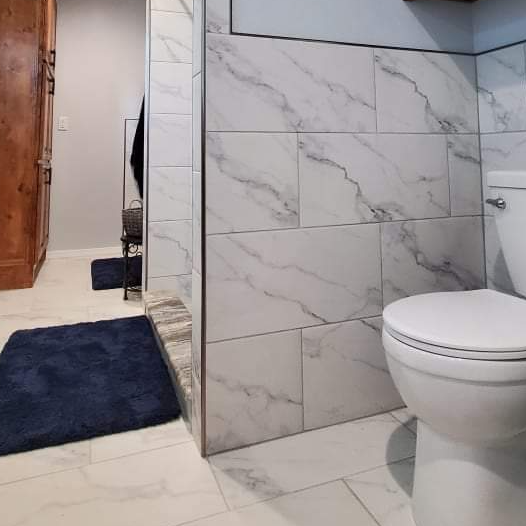 A bathroom with marble tiles and a toilet