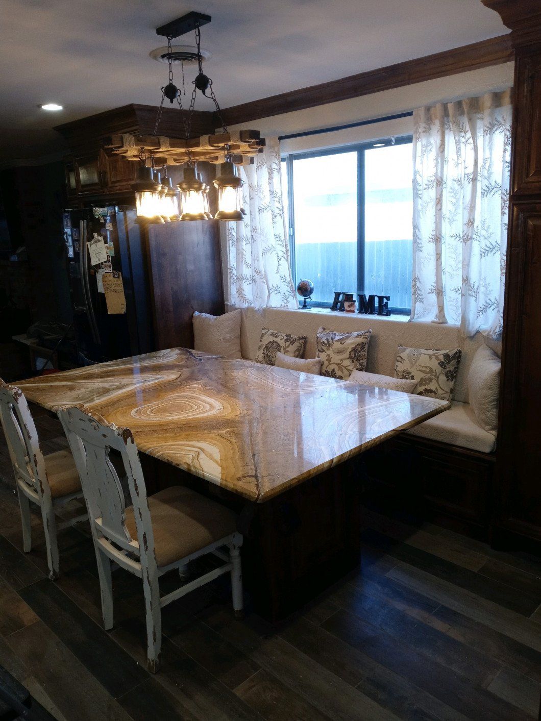 A dining room with a large table and chairs and a window.