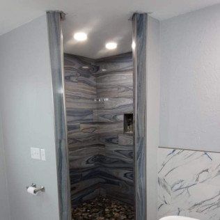 A bathroom with a walk in shower and a toilet.