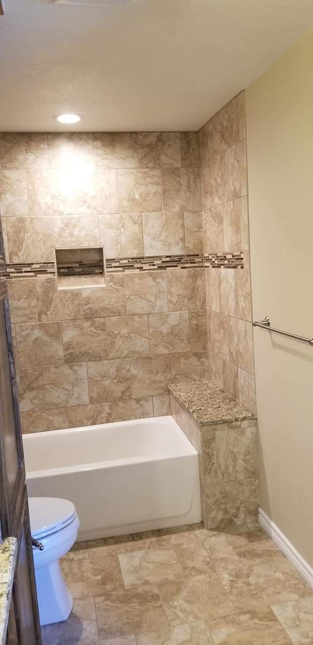 A bathroom with a tub , toilet , and shower.