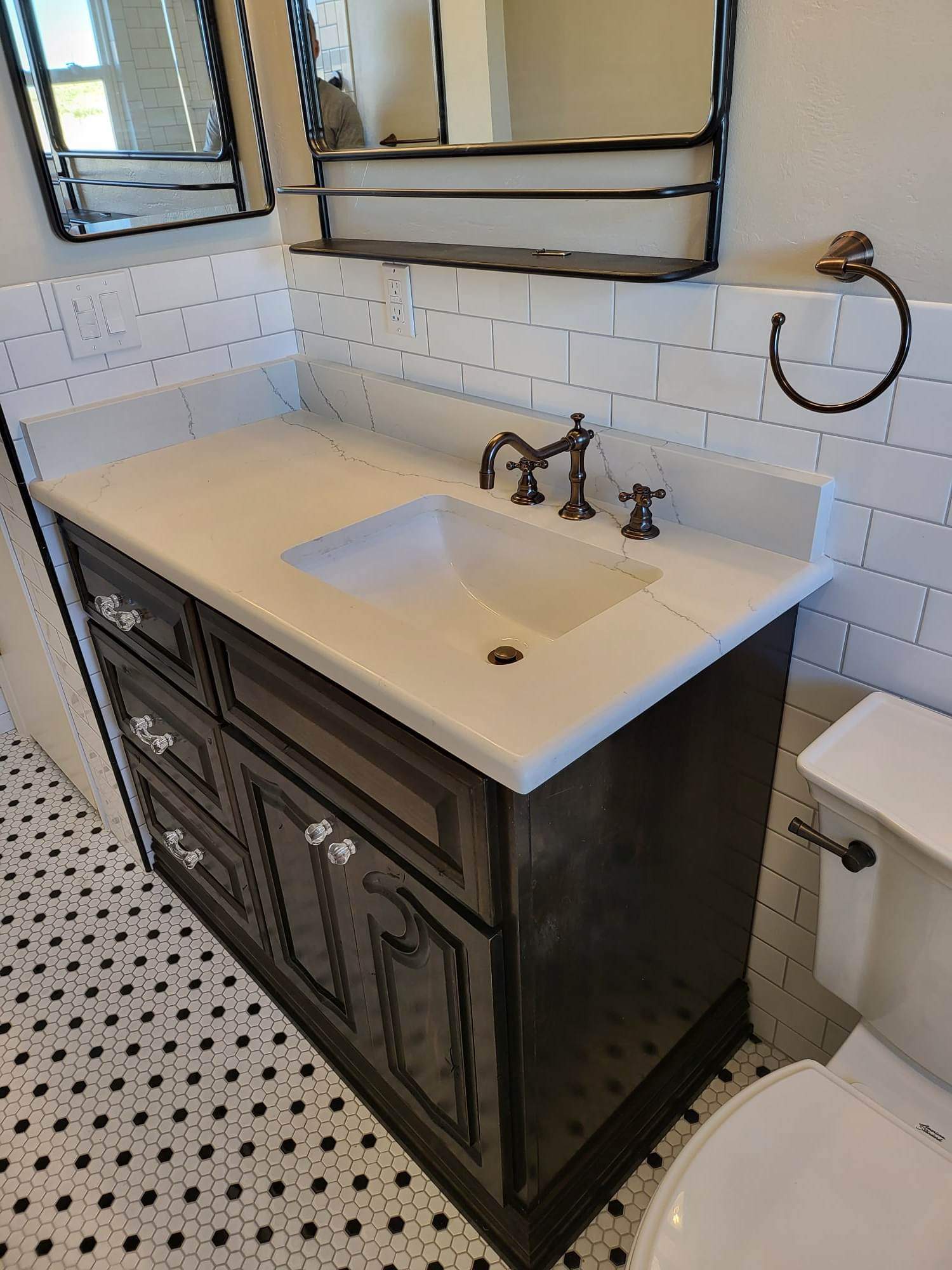 A bathroom with a sink , toilet and mirror.