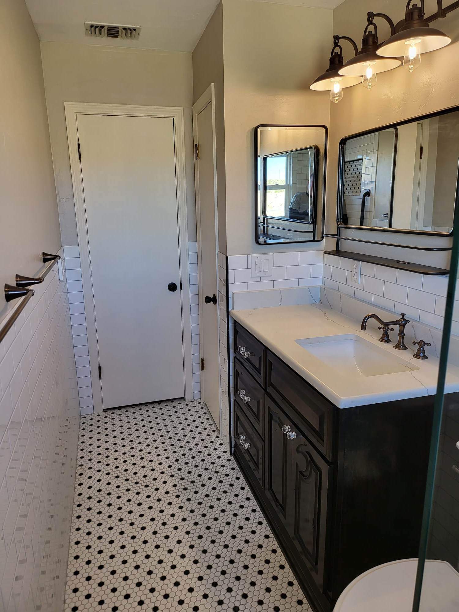 A bathroom with a sink , toilet and mirror.