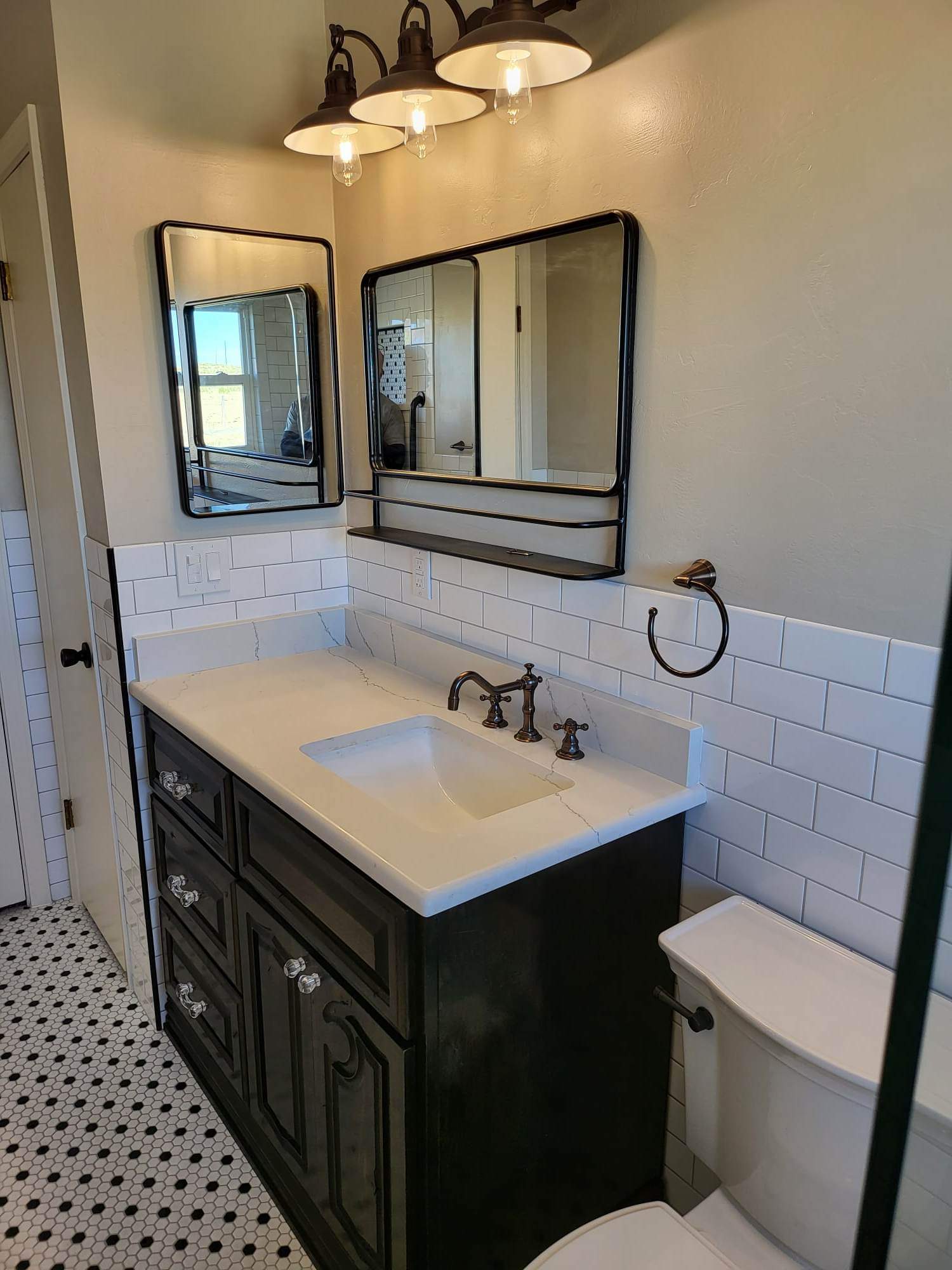 A bathroom with a sink , toilet and mirror.