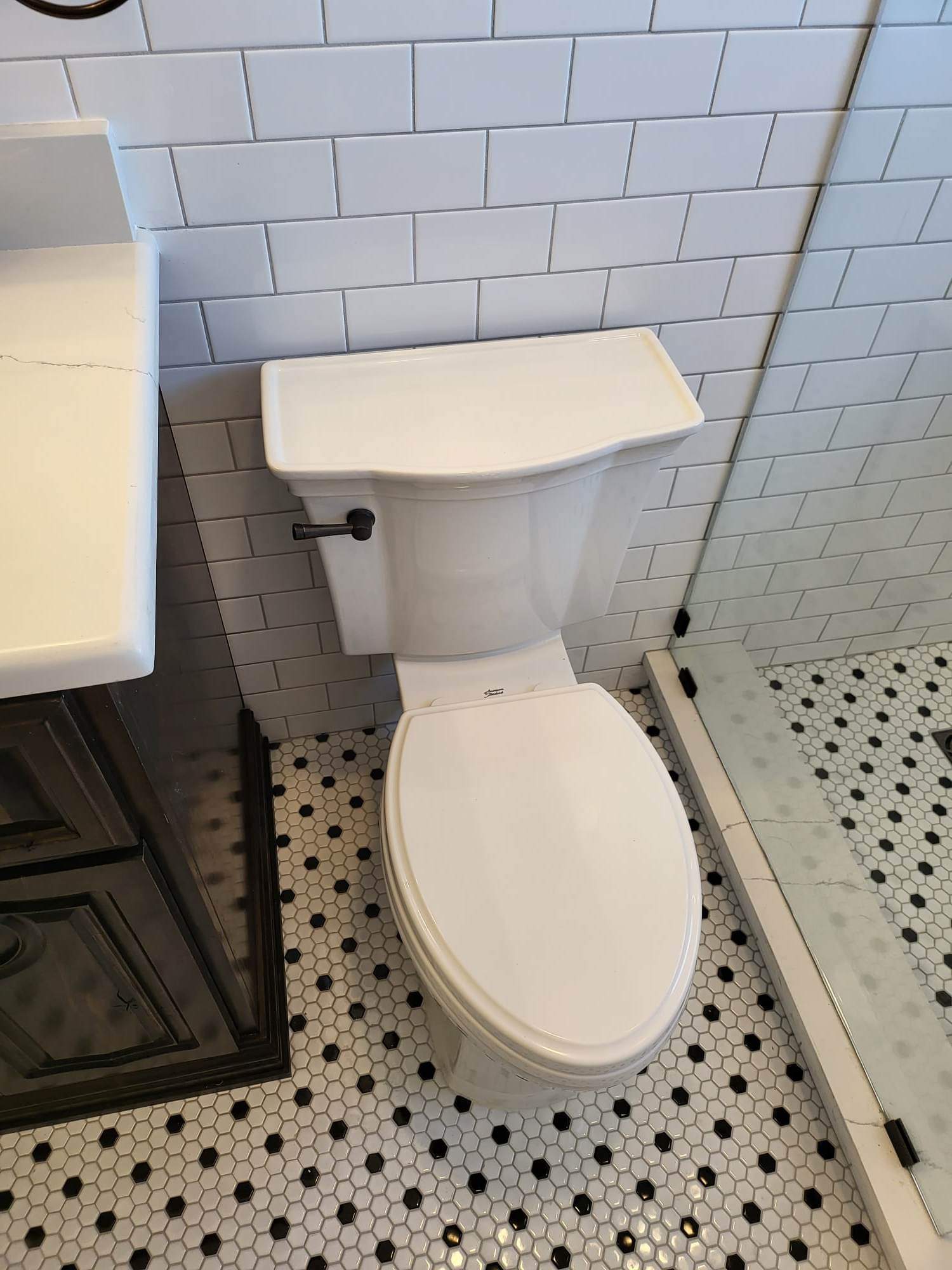 A bathroom with a toilet , sink , and shower.