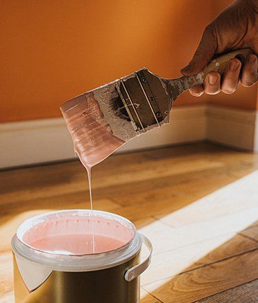 Hand Dipping A Paint Brush Of Pink Paint — Kiama Heights, NSW — Tony Runge Painting Service