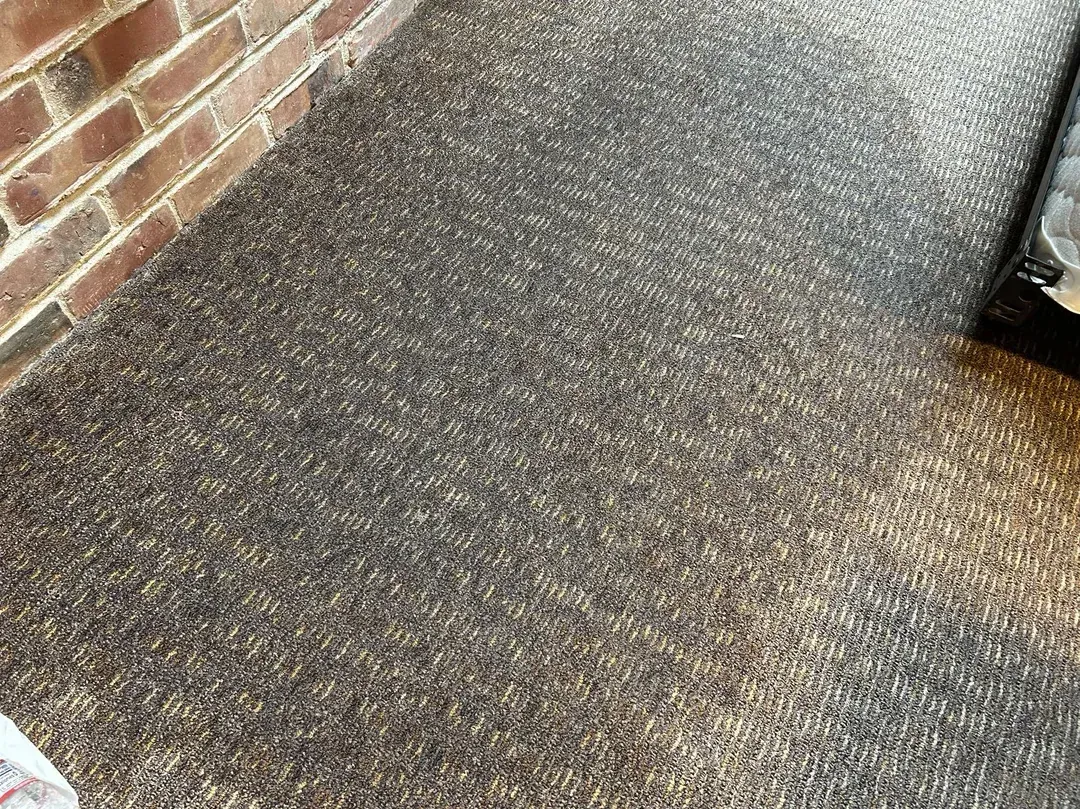 Interior with wooden door to a deck overlooking a body of water with mountains.