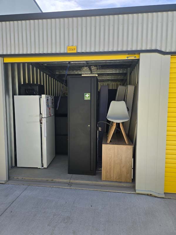 A storage unit filled with appliances including a refrigerator