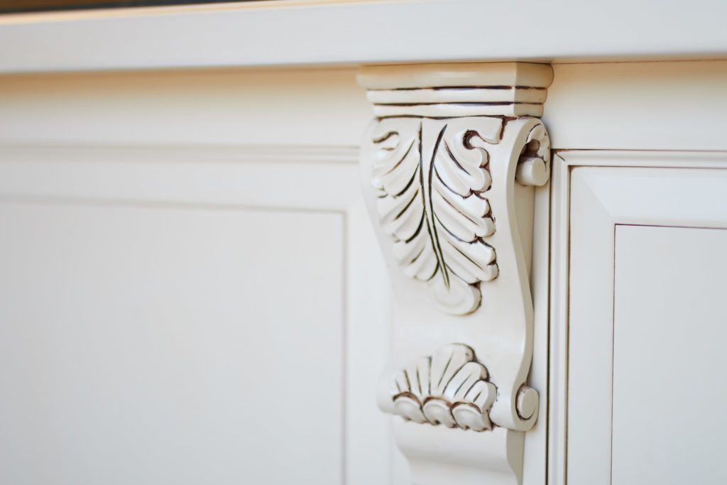 a white cabinet with a corbel on the side of it