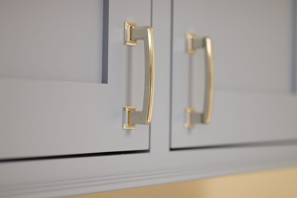 a close up of a kitchen cabinet with gold handles .