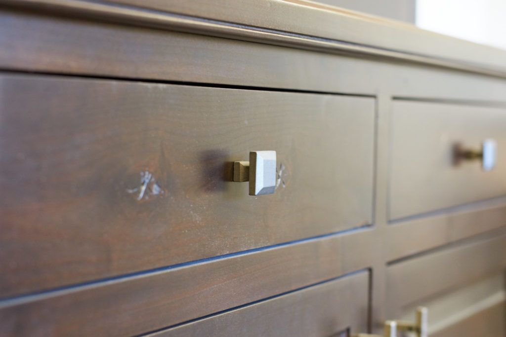 a close up of a wooden dresser with brass handles