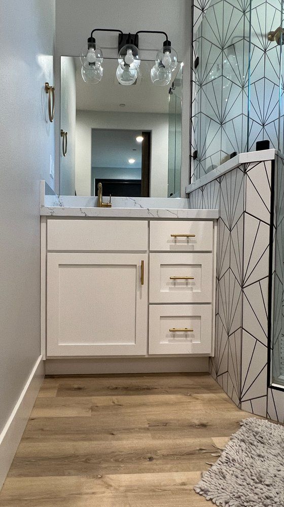 a bathroom with a sink , mirror , and hardwood floor .