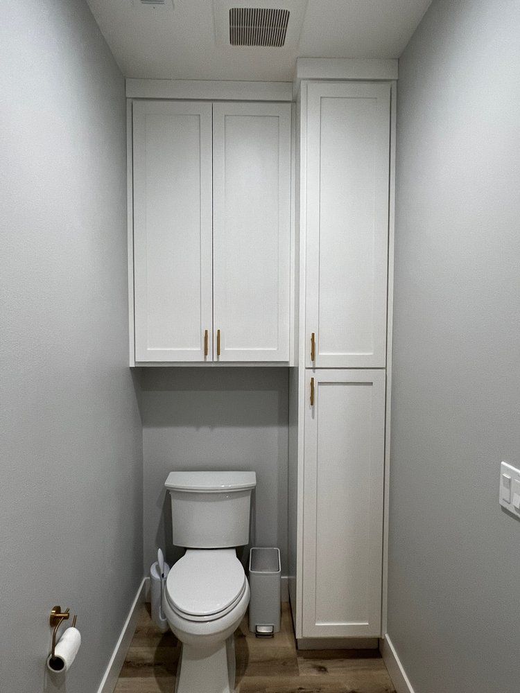 a small bathroom with a toilet and cabinets