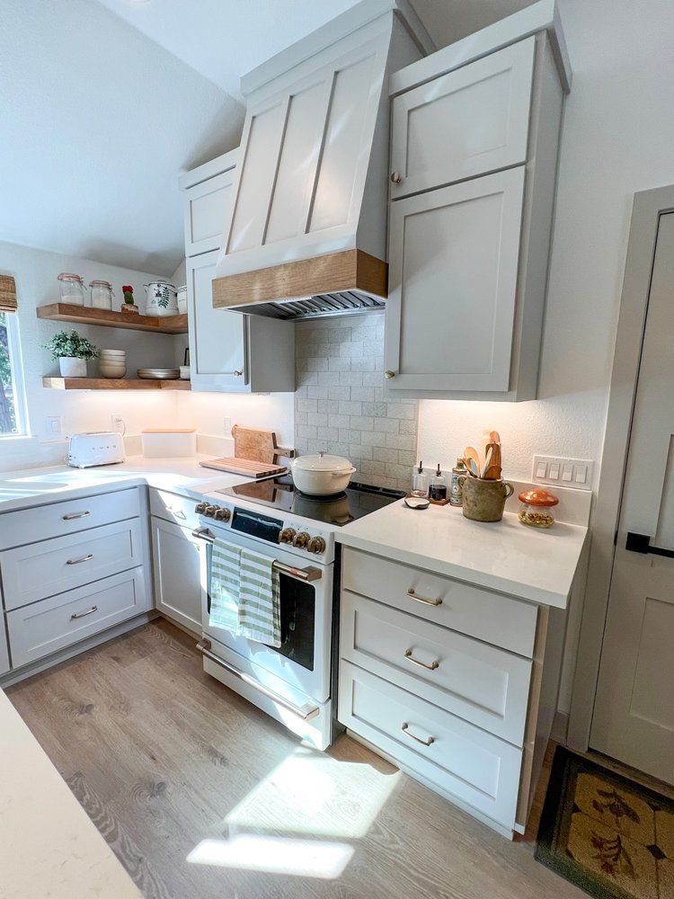 a kitchen with white cabinets and a stove top oven .