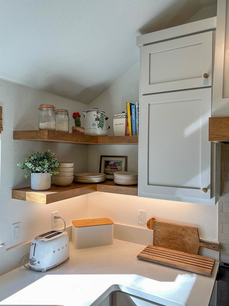 a kitchen with white cabinets , a toaster , a sink and a cutting board .