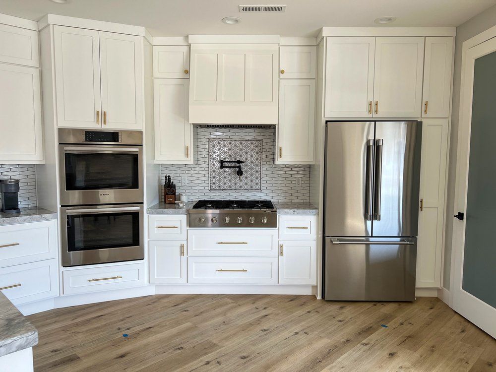 a kitchen with white cabinets and stainless steel appliances