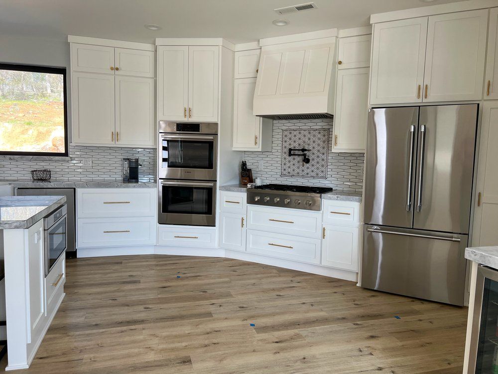 a kitchen with white cabinets and stainless steel appliances .