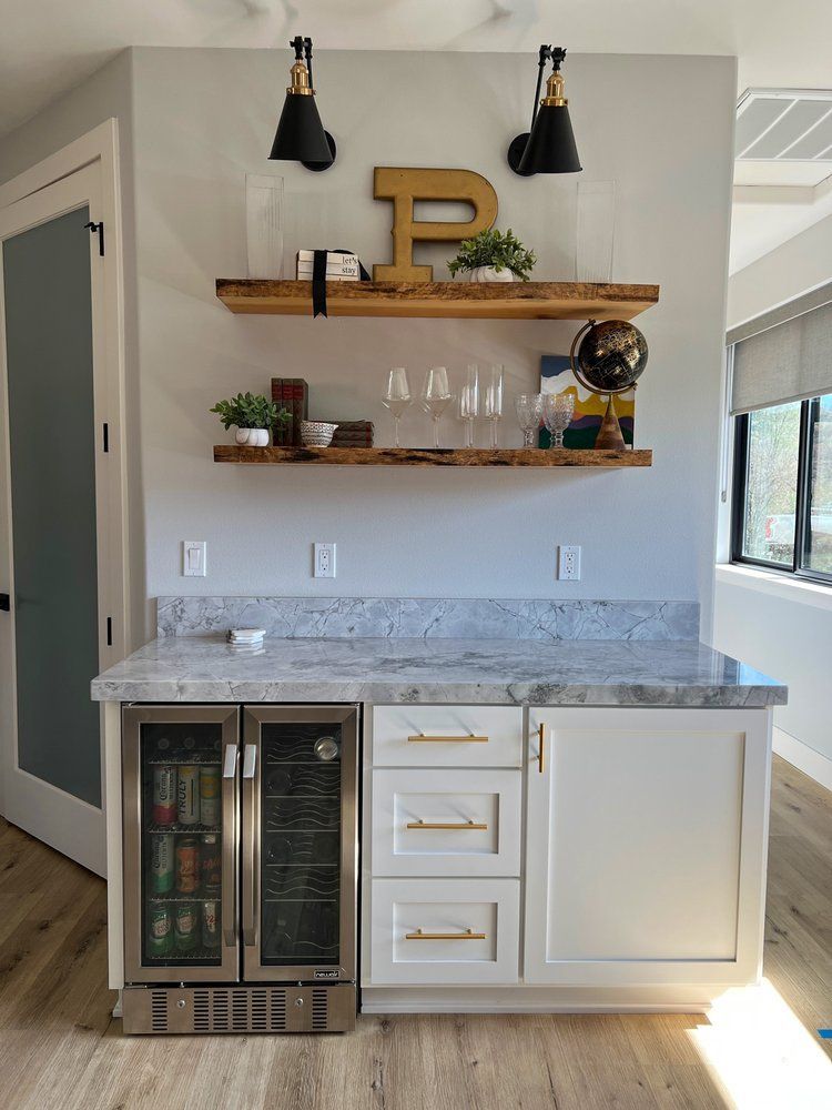 a kitchen with white cabinets , stainless steel appliances , and a refrigerator .