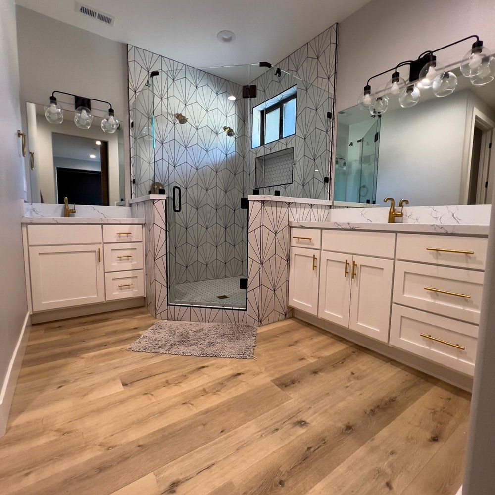 a bathroom with two sinks and a walk in shower .