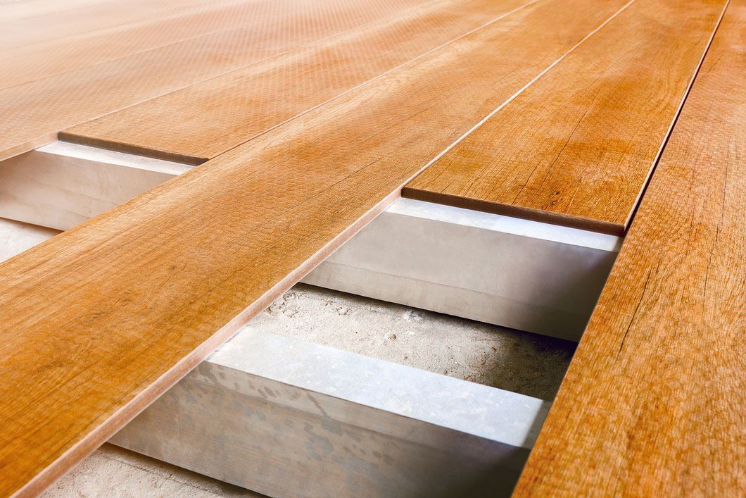 A close up of a wooden floor with a concrete foundation.