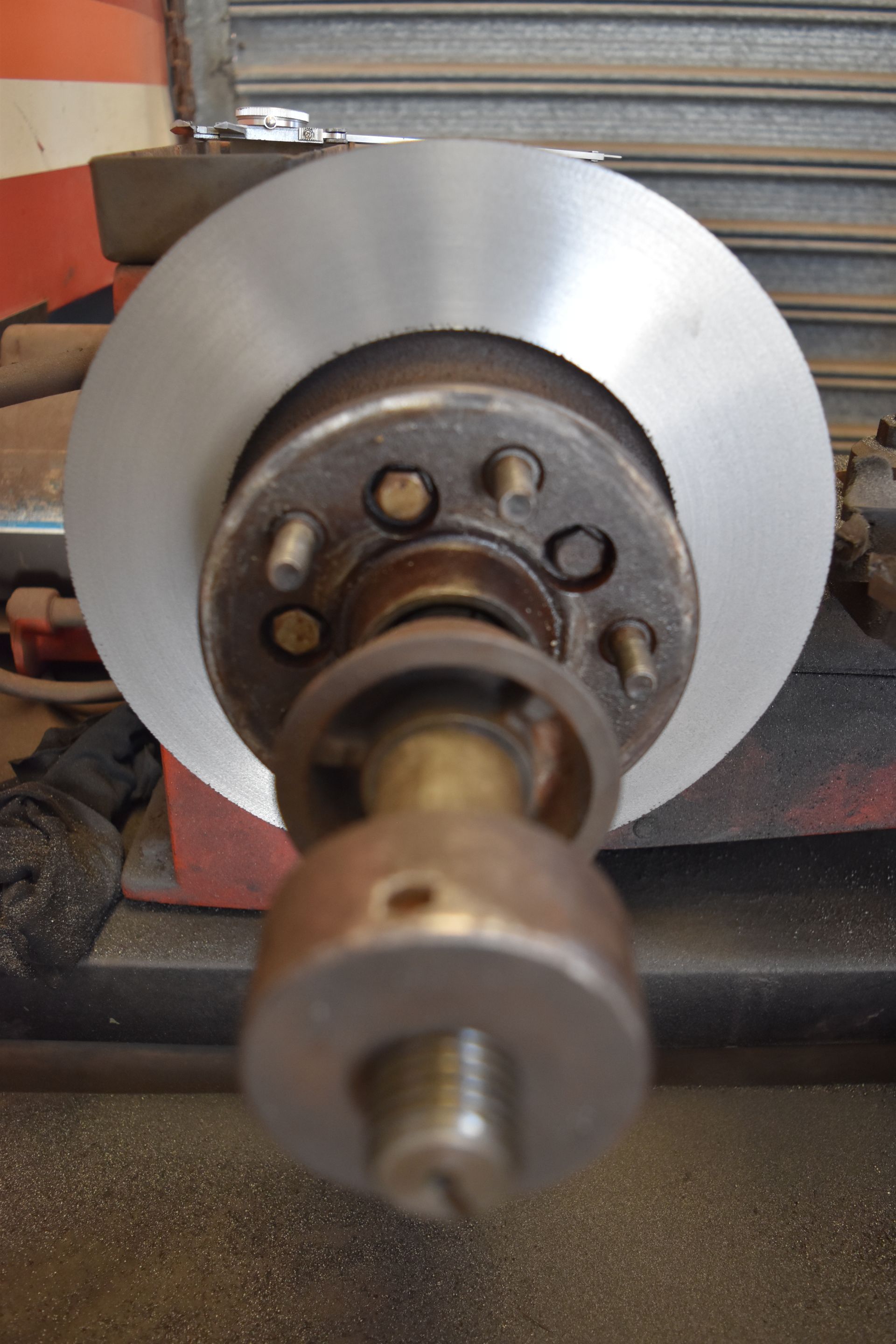 A Mechanic Holding a Worn Car Clutch in Front of an Open Engine — Gladstone Fleet Maintenance In Gladstone, QLD