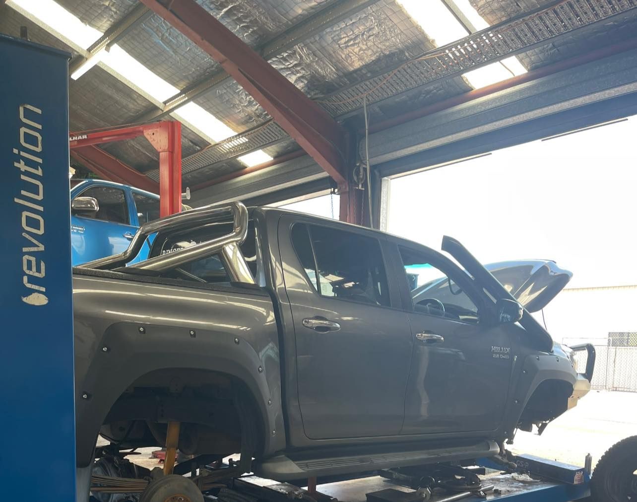 Gray Pickup Truck on a Lift in a Garage, Hood Open — Gladstone Fleet Maintenance In Gladstone, QLD