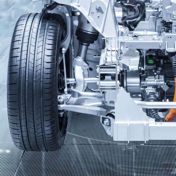 A close up of a car engine with a tire in the foreground