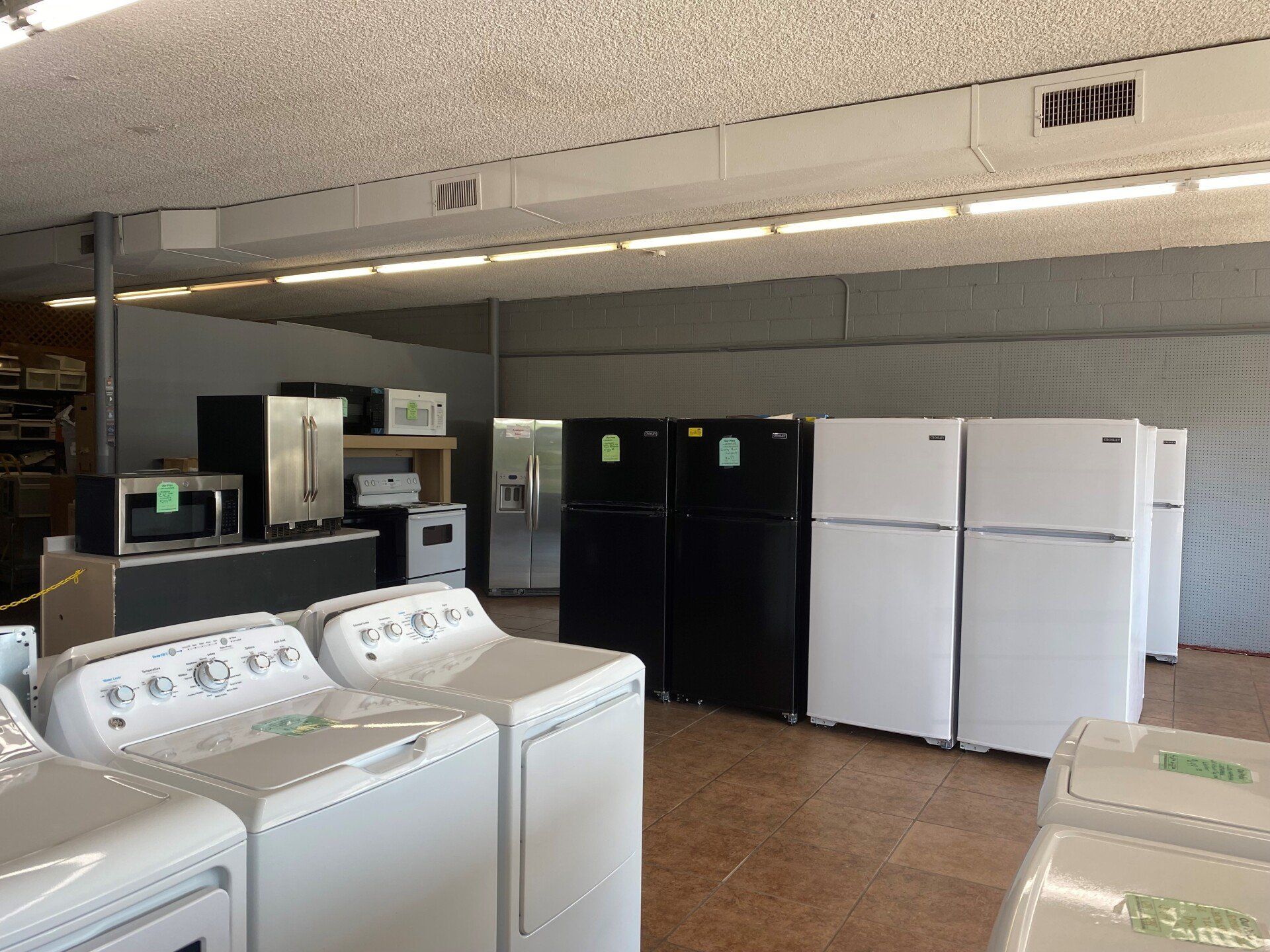 A store filled with a variety of appliances including refrigerators, washers and dryers.