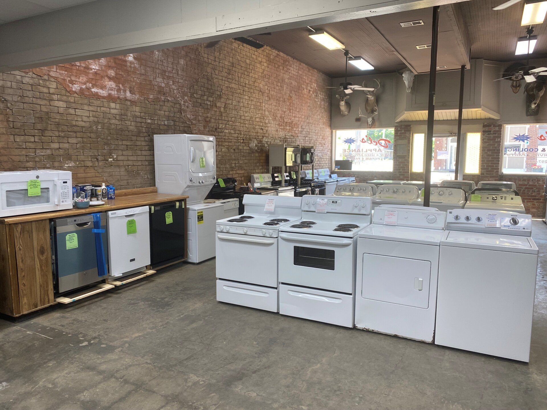 A store filled with lots of white appliances including a stove , washer and dryer.