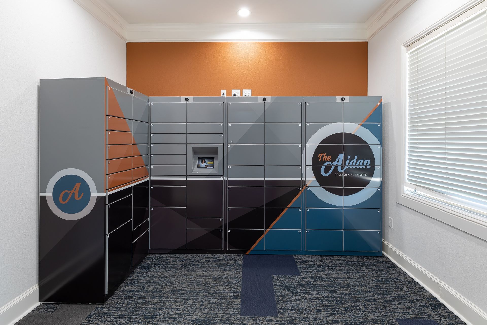 Locker room at The Alden, with a variety of compartments in shades of gray, black, and teal.