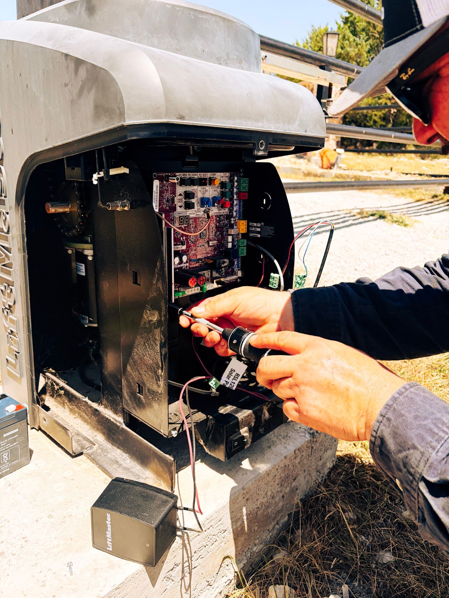 Technician inspecting wiring inside an open utility box outdoors