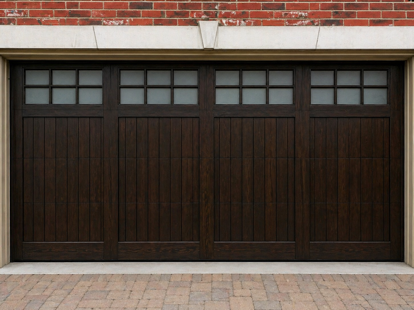 Dark wooden garage door with small window panes beneath a brick exterior wall