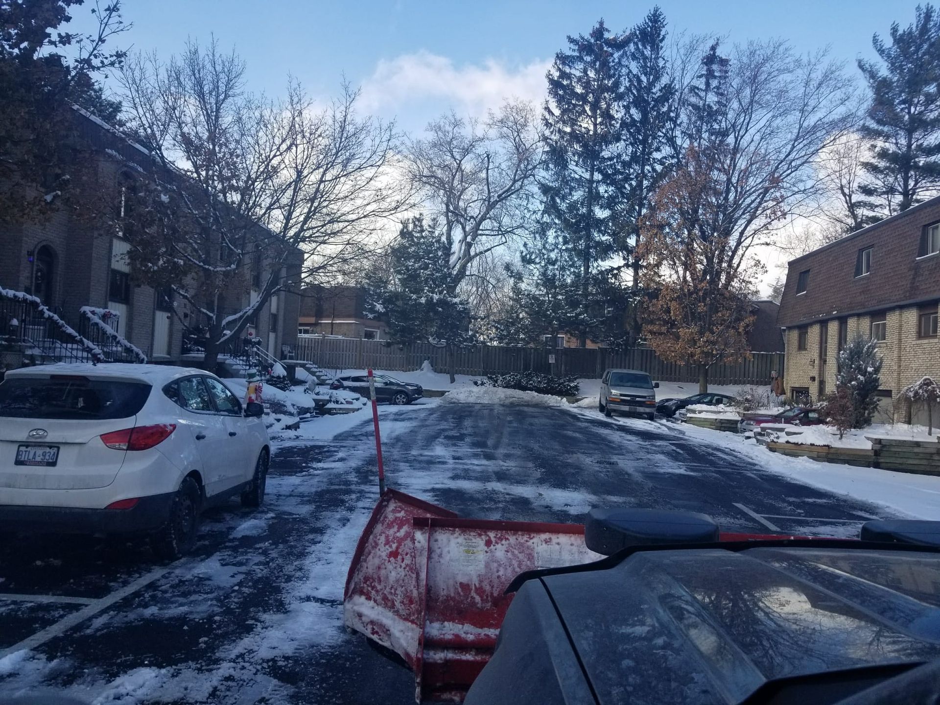A snow plow is clearing snow from a parking lot