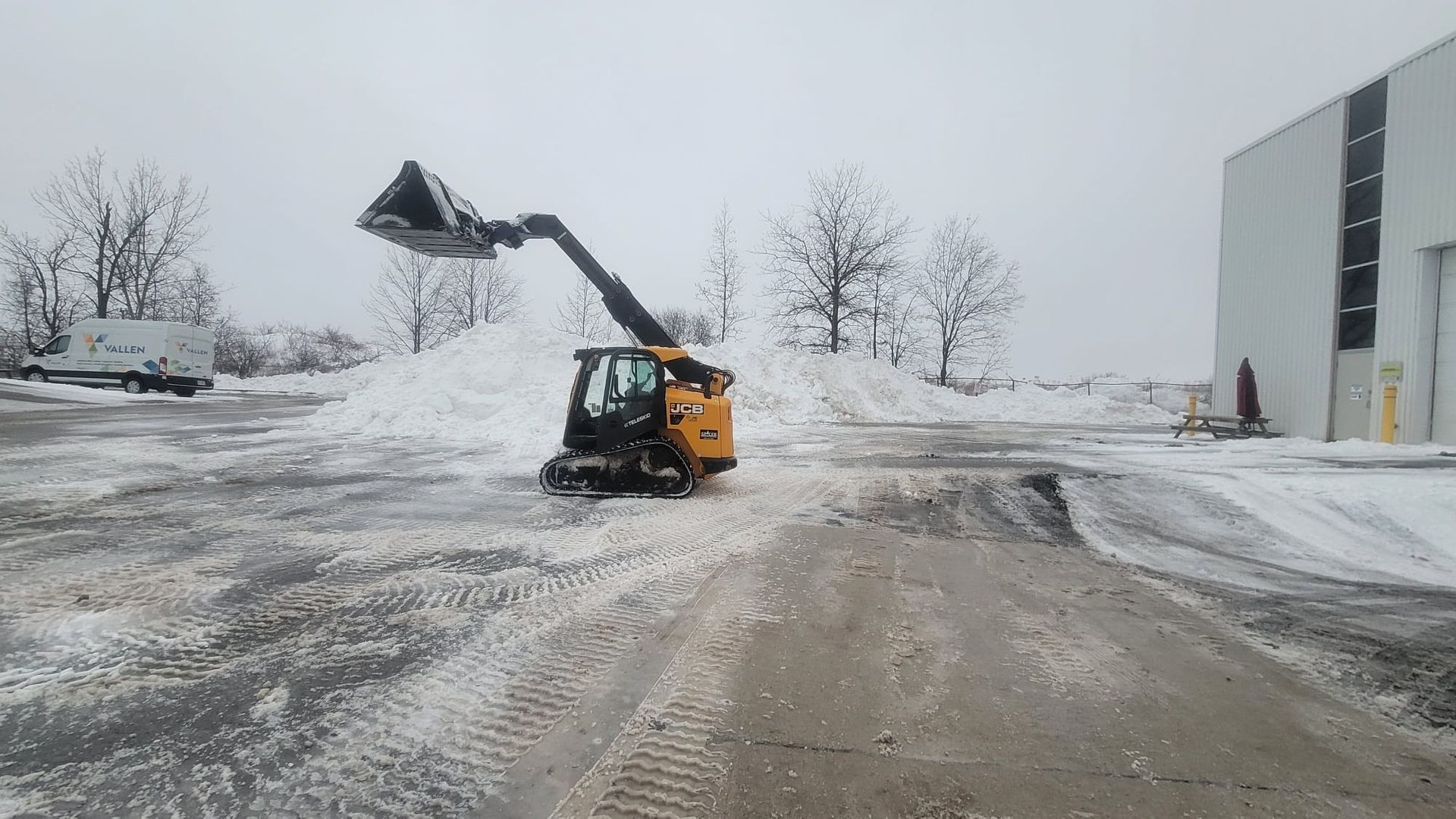 A bulldozer is clearing snow from a parking lot.