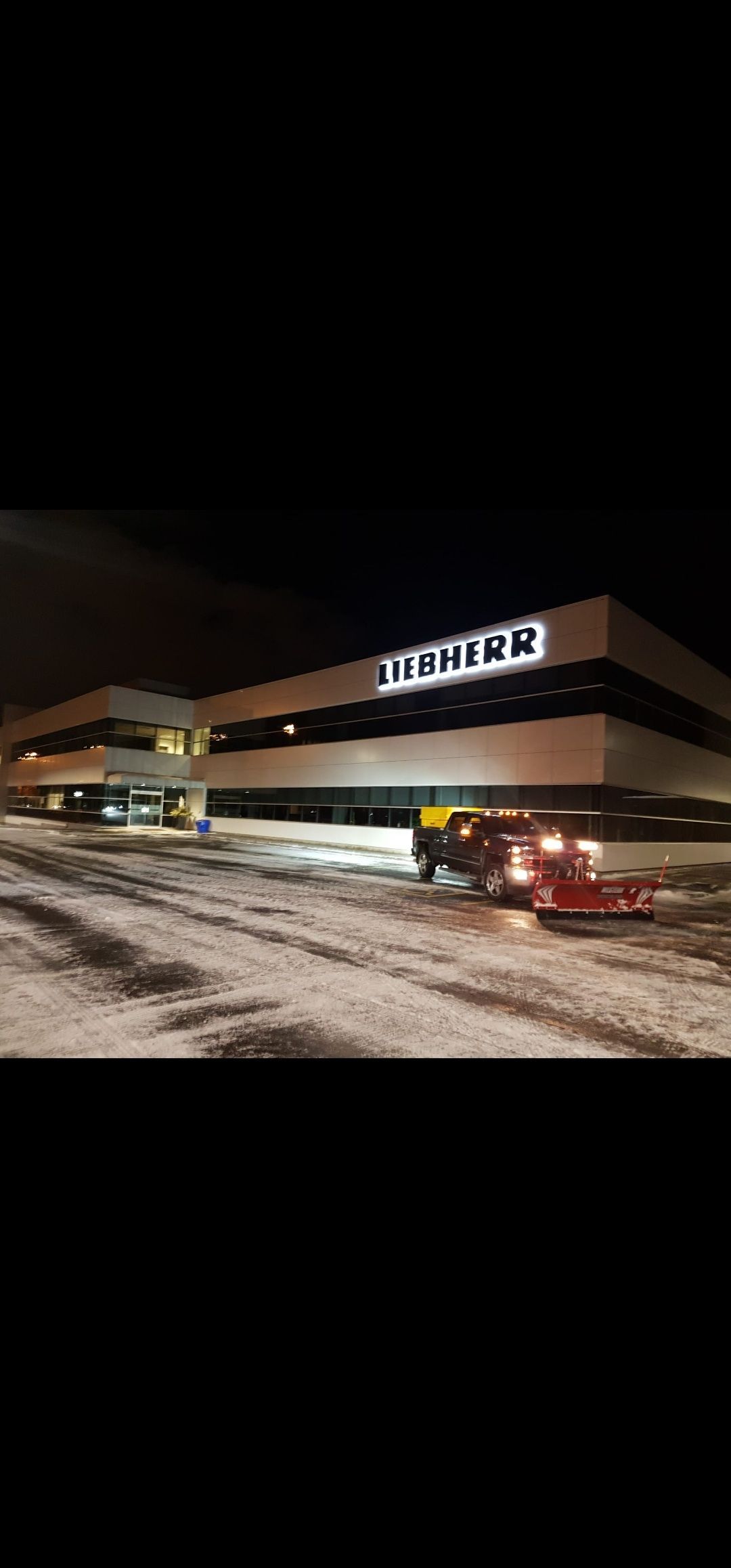 A large building with a lot of snow on the ground in front of it.
