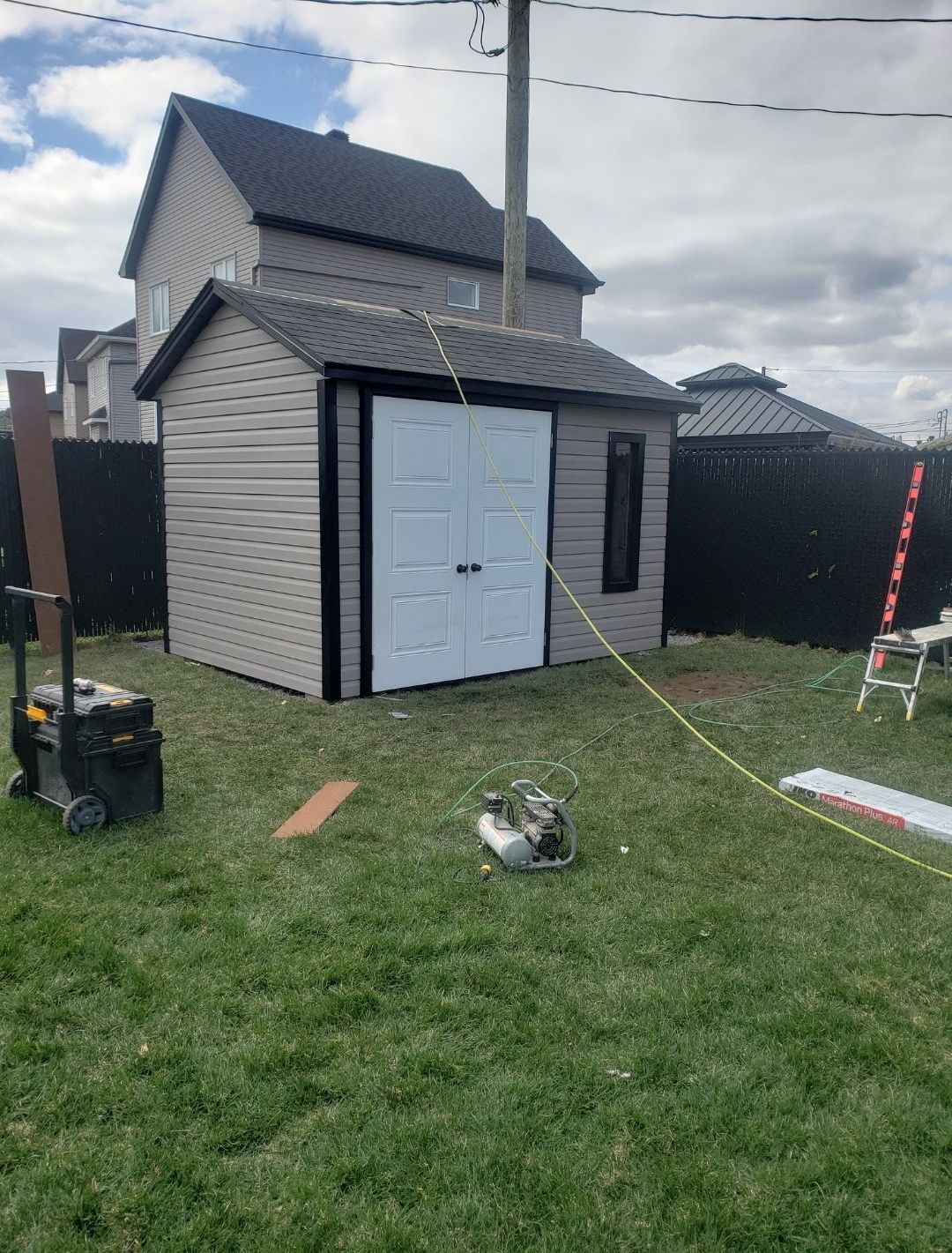 Un hangar est en cours de construction dans l'arrière-cour d'une maison.