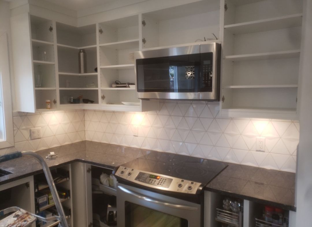 Une cuisine avec électroménagers en acier inoxydable et un four à micro-ondes.