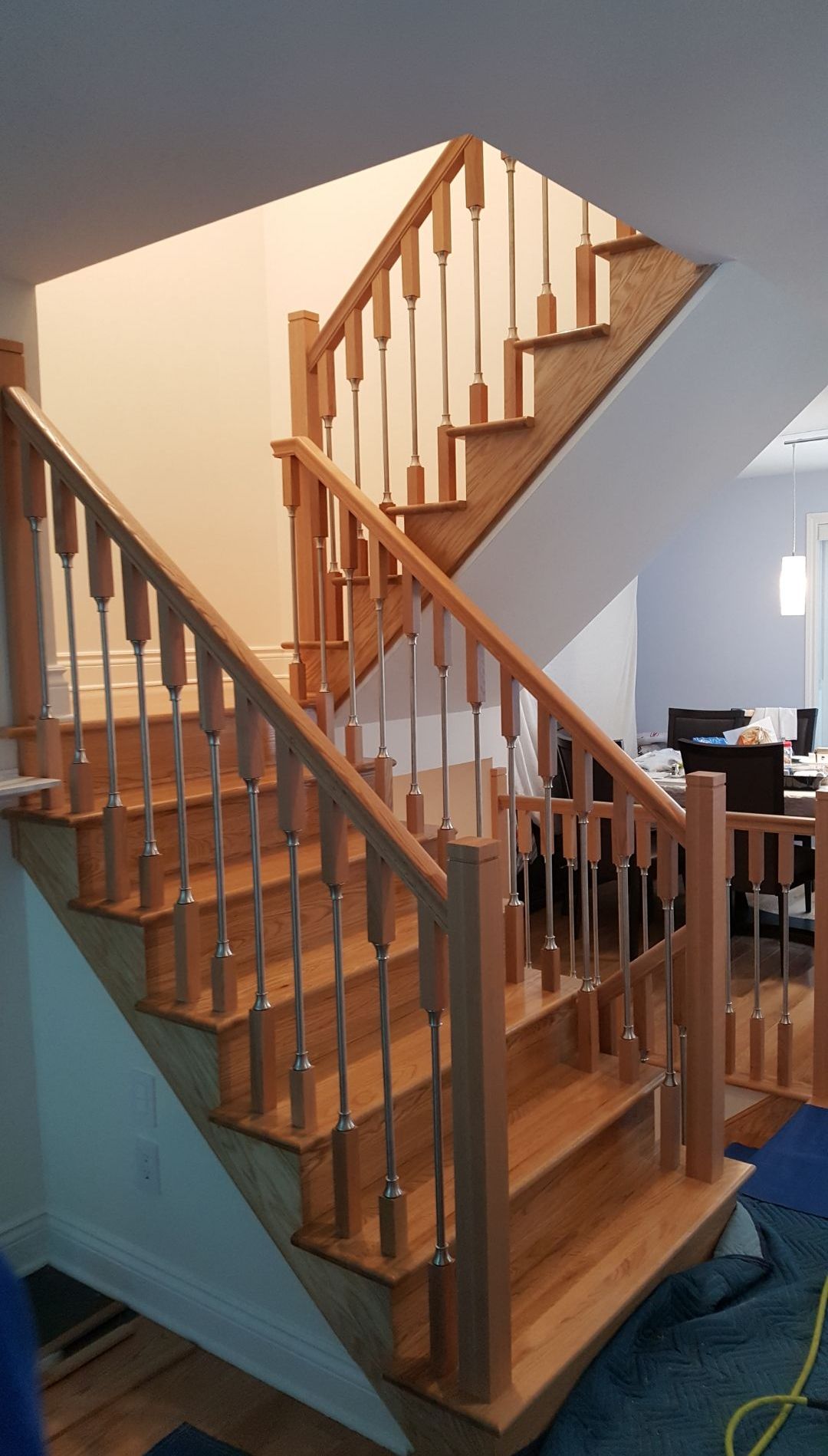 Un escalier en bois dans une maison avec une rampe en métal