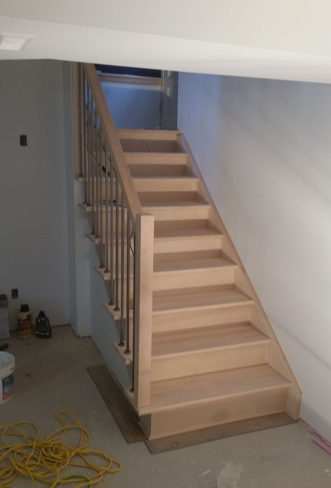 Un escalier en bois avec une rampe en métal dans une pièce.