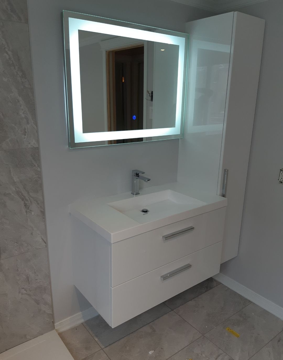 Une salle de bain avec lavabo, miroir et armoires.