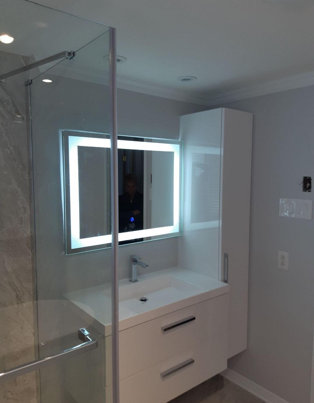 Une salle de bain avec un lavabo un miroir et une douche à l'italienne